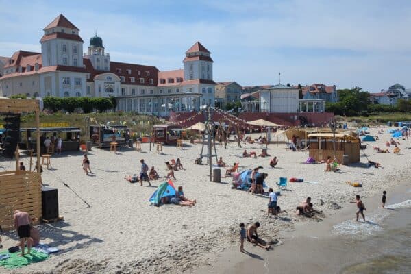 Binzer Strand mit Kurhaus im Hintergrund und Strandaktivitäten