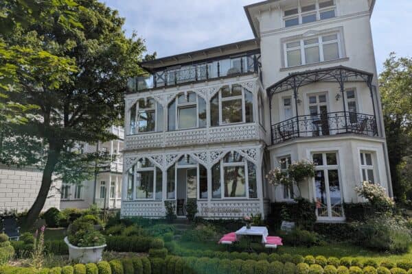 Historische Villa in Sellin mit weißen Holzveranden und gepflegtem Garten