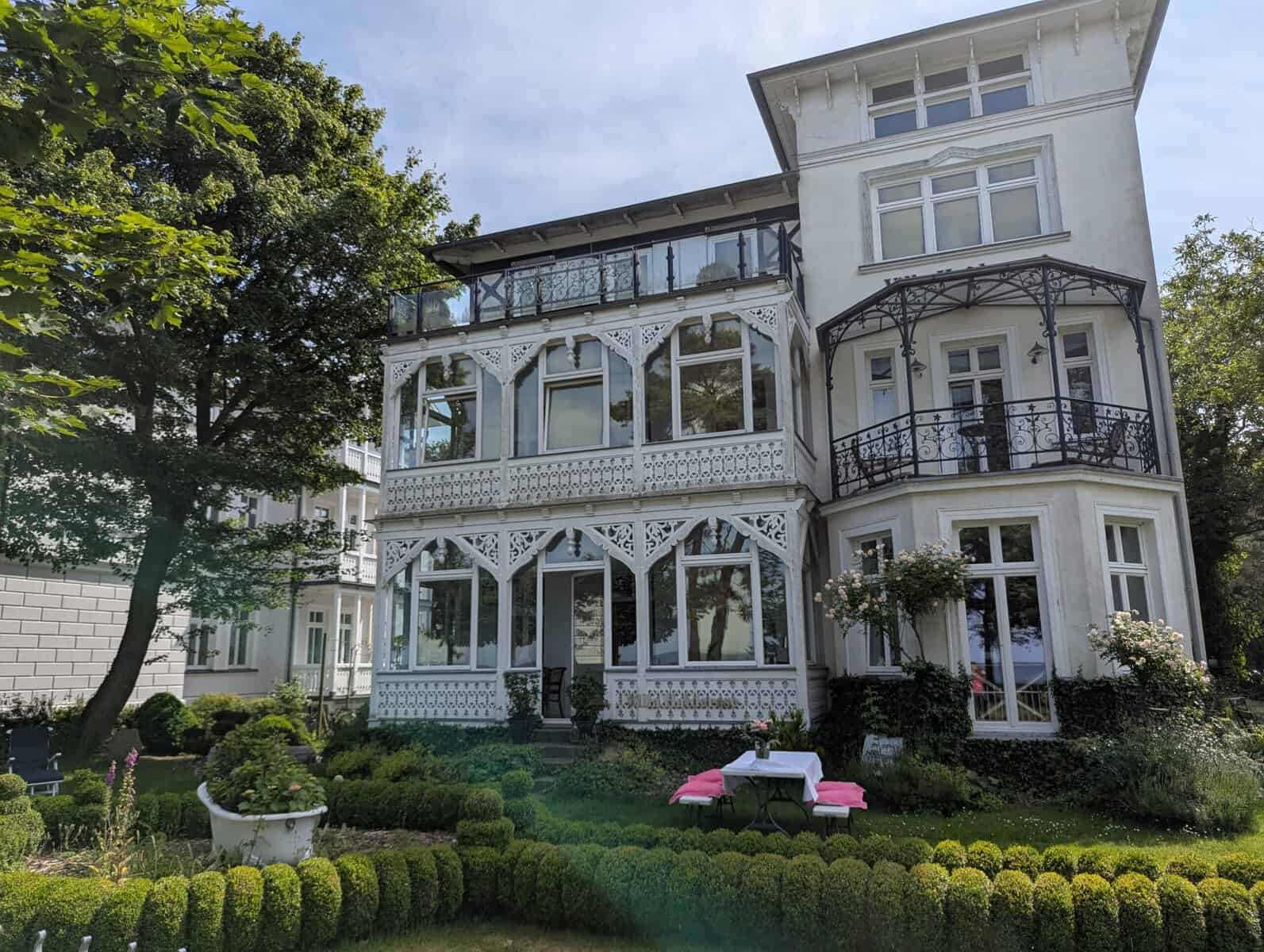 Historische Villa in Sellin mit weißen Holzveranden und gepflegtem Garten